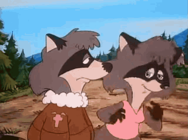 a couple of raccoons are standing next to each other on a dirt road