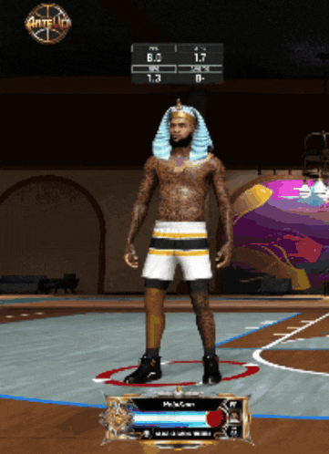 a man in a pharaoh costume is standing on a basketball court in front of a scoreboard that says anteup