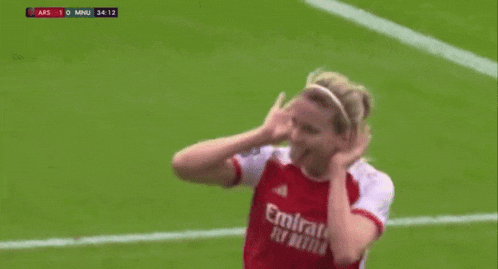 a female soccer player wearing a red emirates fly better jersey