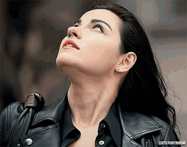 a woman in a black leather jacket is looking up and the words edits portiranoni are on the bottom