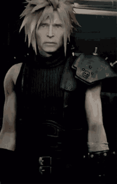 a man with blonde hair is wearing a black tank top and a black armor .
