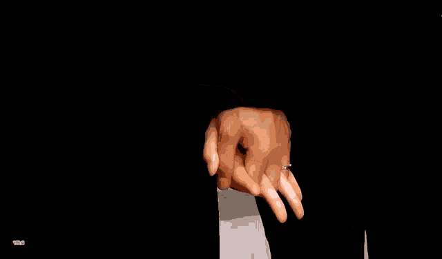 a man and a woman are holding hands and the woman has a wedding ring on her finger .