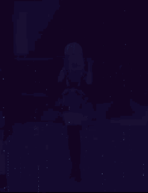 a girl in a blue dress stands in the dark