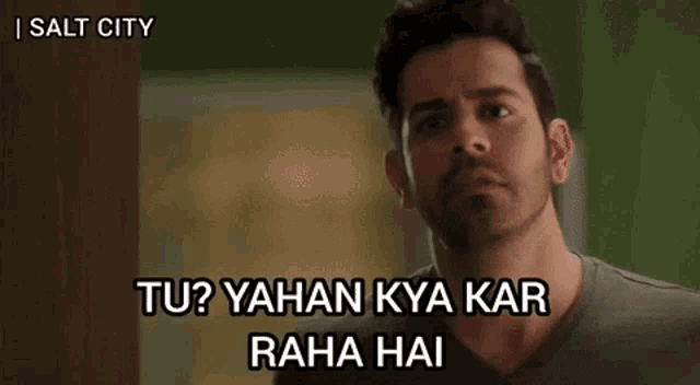 a man with a beard is making a funny face and says tu ? yahan kya kar raha hai .
