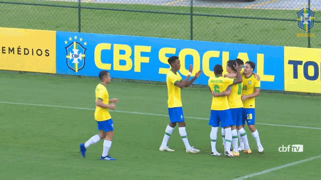 soccer players on a field in front of a banner that says cbf social to