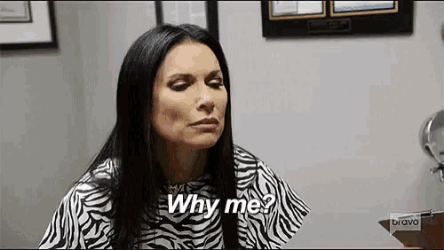 a woman is sitting in front of a mirror and asking why me ?