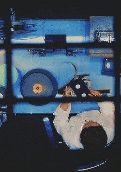 a woman is laying down in front of a blue machine holding a cd