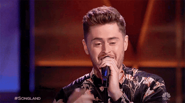 a man singing into a microphone with the words songland on the bottom right
