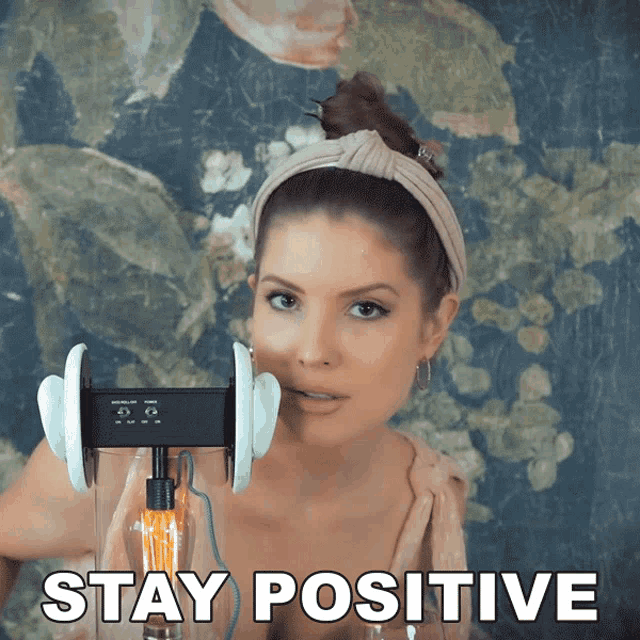 a picture of a woman with ear buds and the words stay positive