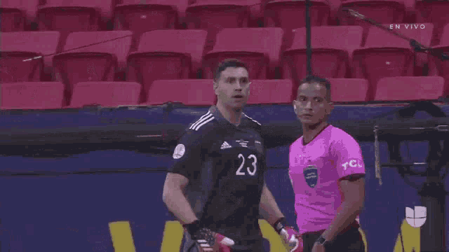 a man wearing a jersey with the number 23 on it is standing next to another man .