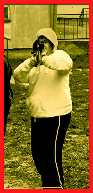 a woman wearing a nike hoodie holds a gun
