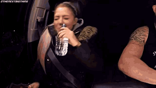a man and a woman are sitting in a car laughing .