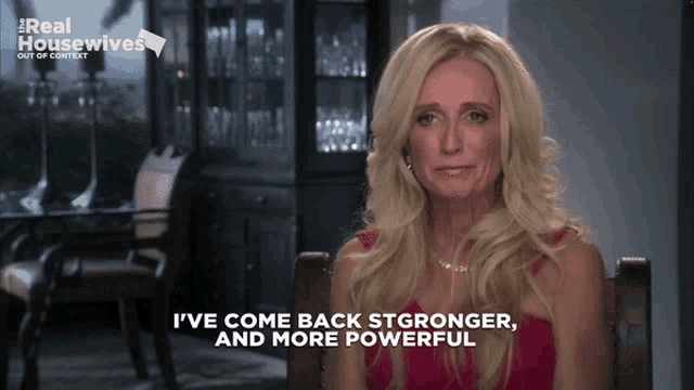 a woman says i 've come back stronger and more powerful in front of a sign that says real housewives