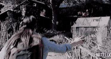 a woman with a backpack is pointing to a greenhouse in a netflix ad