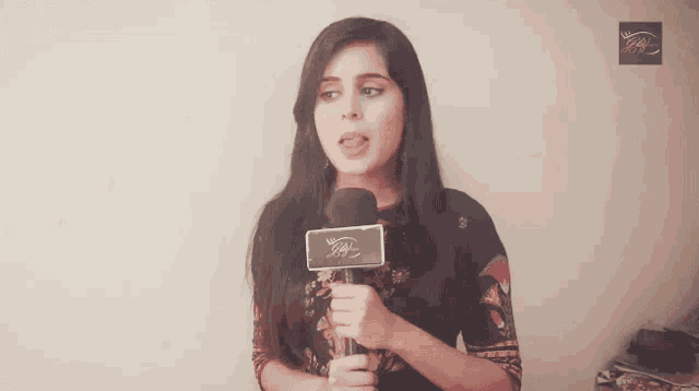 a woman is holding a microphone with a label that says ' ipl ' on it