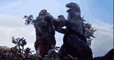 two monsters are standing next to each other on top of a rock .