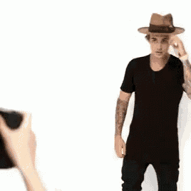 a man in a hat is being photographed by a camera .