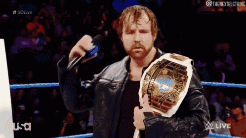 a man in a leather jacket is holding a world heavyweight wrestling championship belt