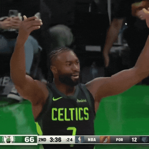 a celtics player with his arms in the air celebrating