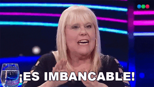 a woman sitting at a table with the words " es imbancable " written on the screen