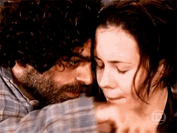 a man and a woman are hugging each other .