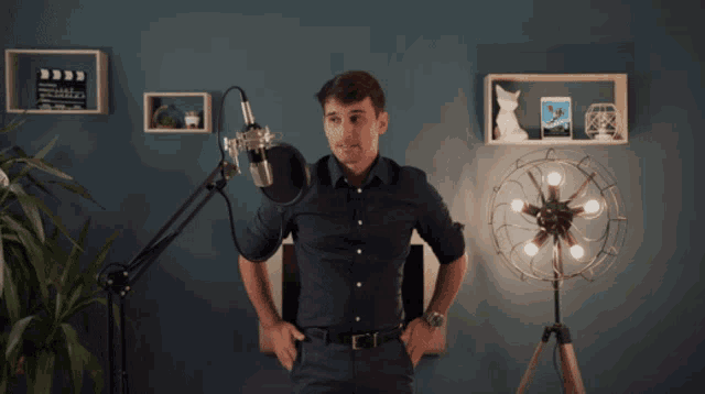 a man stands in front of a microphone in a room