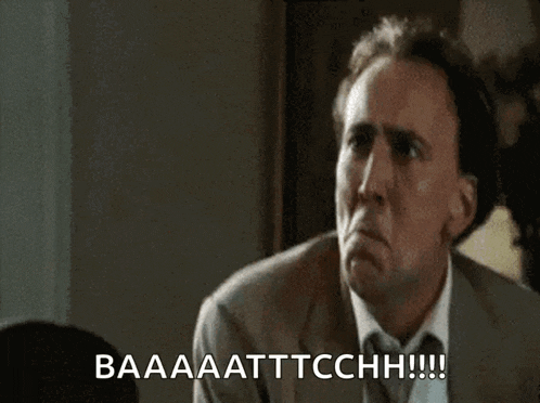 a man in a suit and tie is making a funny face and saying baaa attcchhh .