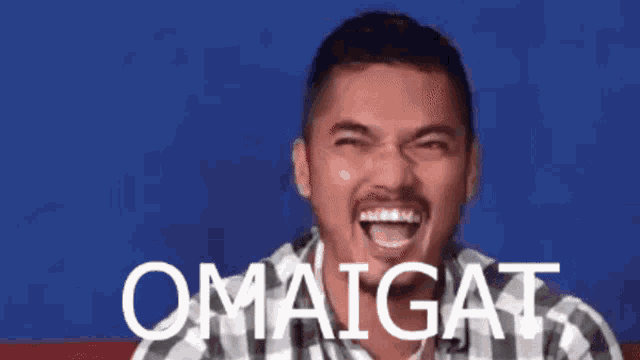 a man in a plaid shirt is laughing and the word omaigat is on the screen