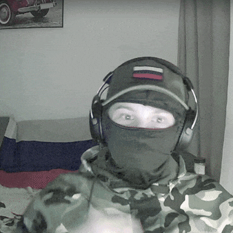 a person wearing a mask and headphones with a russian flag patch on their hat