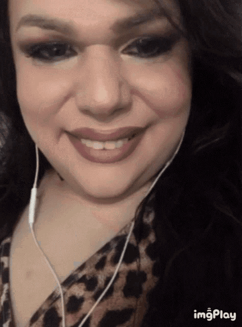 a woman wearing headphones and a leopard print shirt is smiling