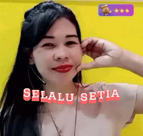 a woman is wearing a headset and making a funny face with the words selalu setia written on the bottom .
