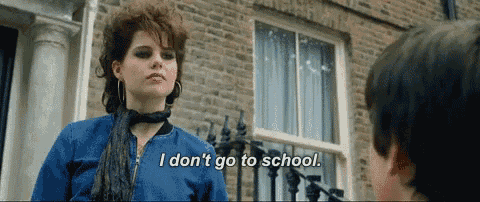 a woman is standing in front of a brick building and says i don 't go to school