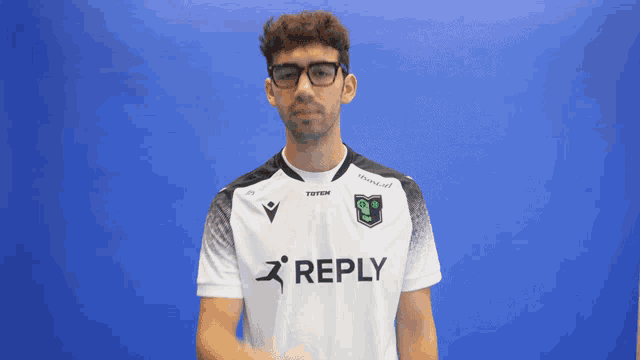 a man wearing glasses and a white shirt with the word reply on it