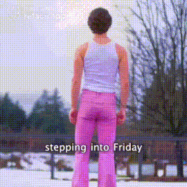 a man in pink pants and a white tank top is standing in the snow .