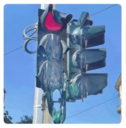 a broken traffic light with a red light and a green light on a pole .