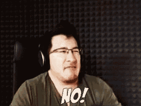 a man wearing headphones is sitting in front of a wall and saying no .