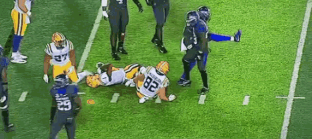 a group of football players are playing a game on a field .