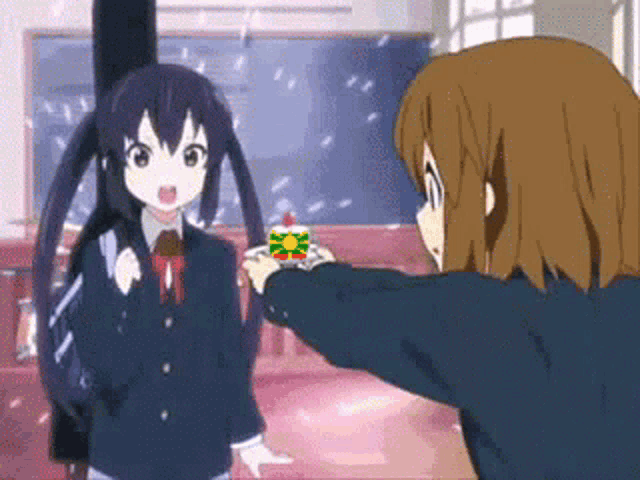two anime girls are standing next to each other in a room . one of the girls is giving a gift to the other .