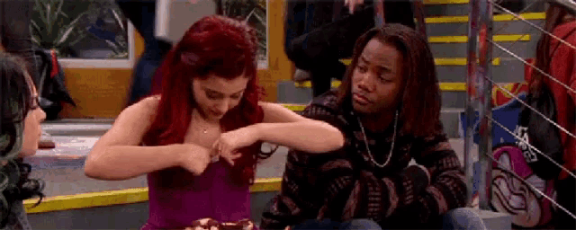 a man and a woman are sitting next to each other on the floor