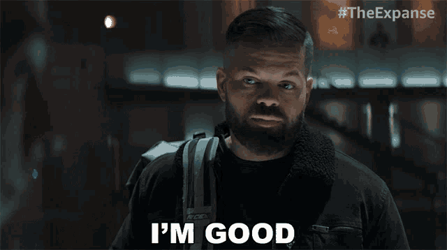 a man with a beard says i 'm good while holding a backpack