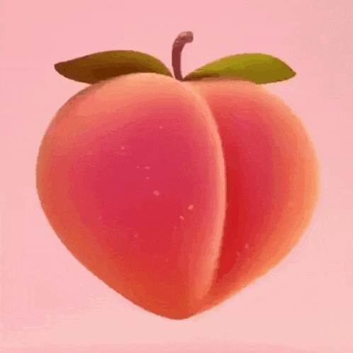 a person is holding a peach with a green leaf on a pink background .