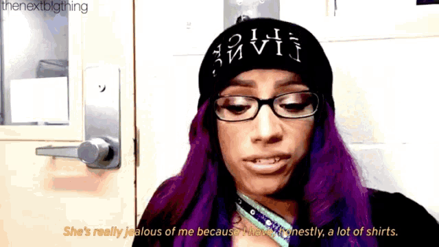 a woman with purple hair wearing glasses and a beanie says she 's really jealous of me