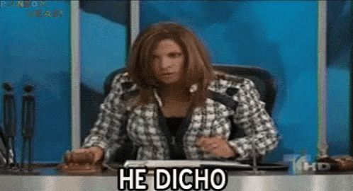 a woman in a plaid jacket is sitting at a desk and says he dicho