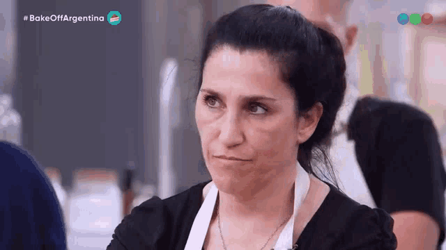 a woman making a funny face while watching a bake off argentina show
