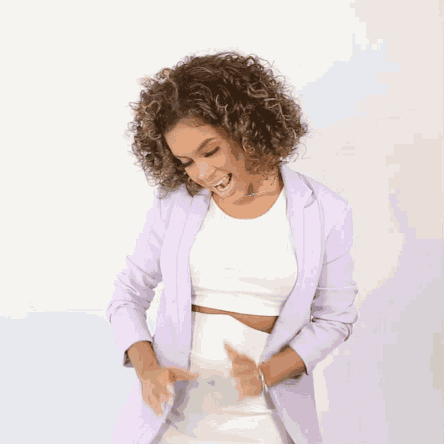 a woman wearing a purple jacket and white top is dancing