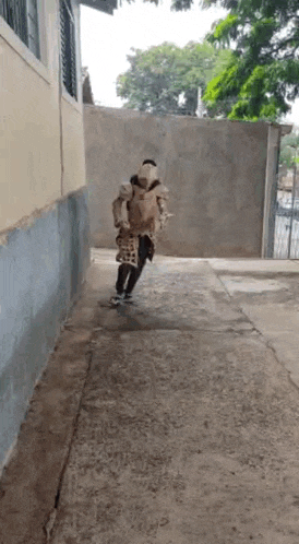 a man is walking down a sidewalk carrying a goat on his back .