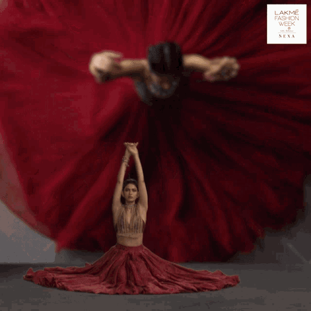 a poster for lakme fashion week shows a woman in a red dress flying through the air