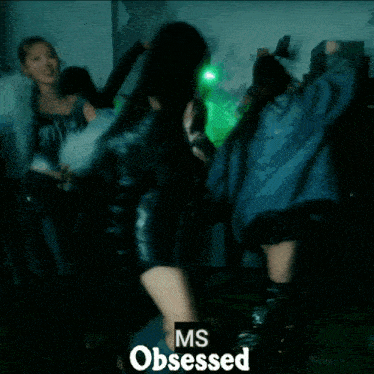 a group of women are dancing in a dark room with the words ms obsessed on the bottom