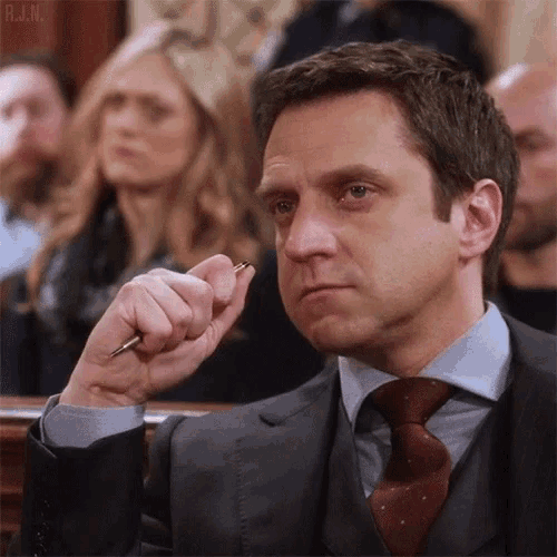 a man in a suit and tie is holding a pen .