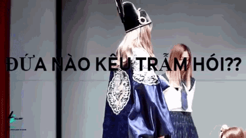 a woman wearing a hat with the number 6 on it is standing in front of a sign that says dua nao keu tramhoi